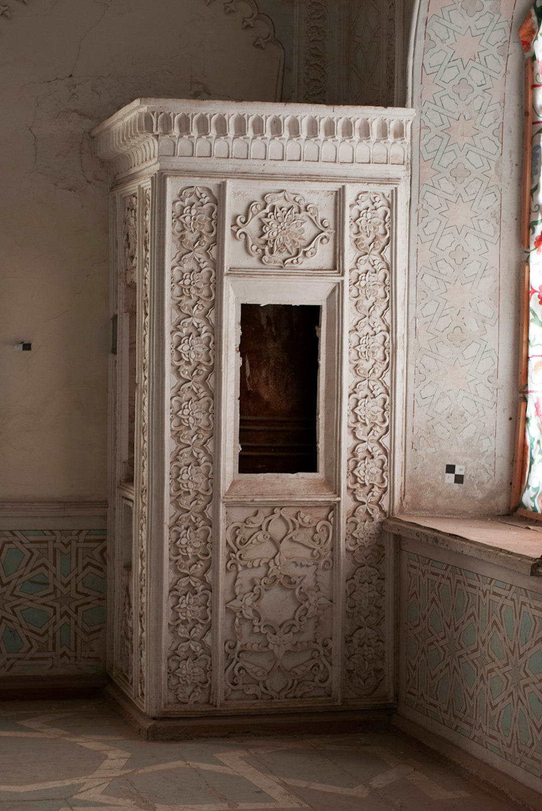 A room with a window and a white cabinet