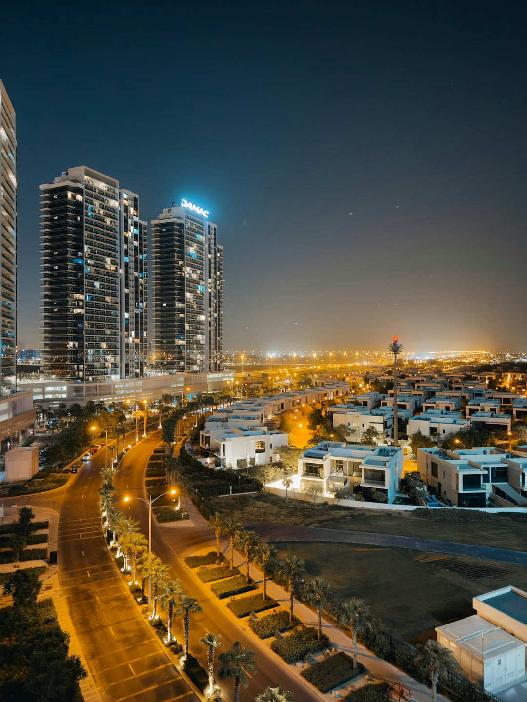 Modern city skyline with illuminated buildings and streets at night.