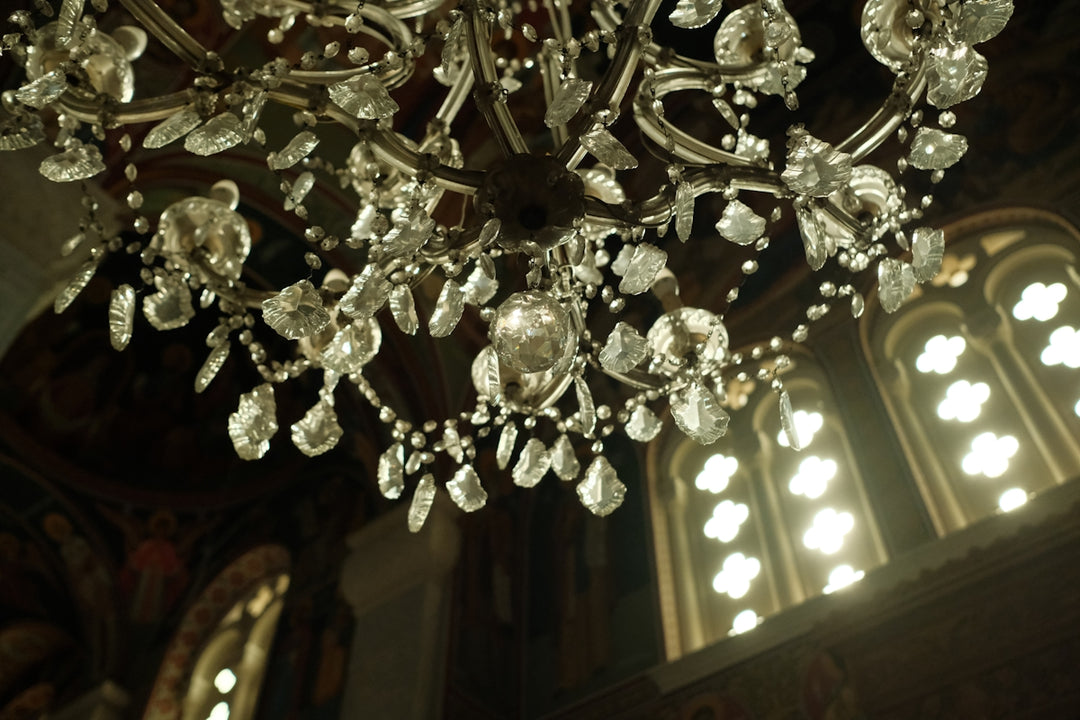 Ornate crystal chandelier hanging in a dimly lit room.