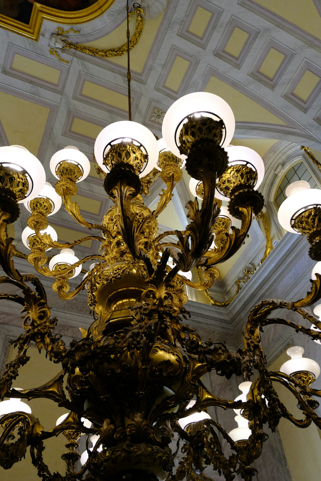 An ornate golden chandelier hangs from ceiling.