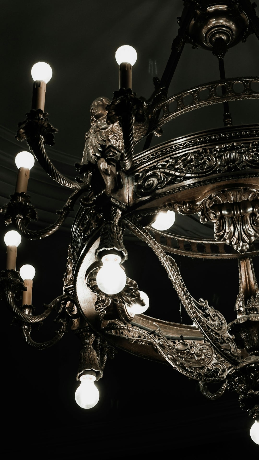 An ornate antique chandelier with glowing bulbs