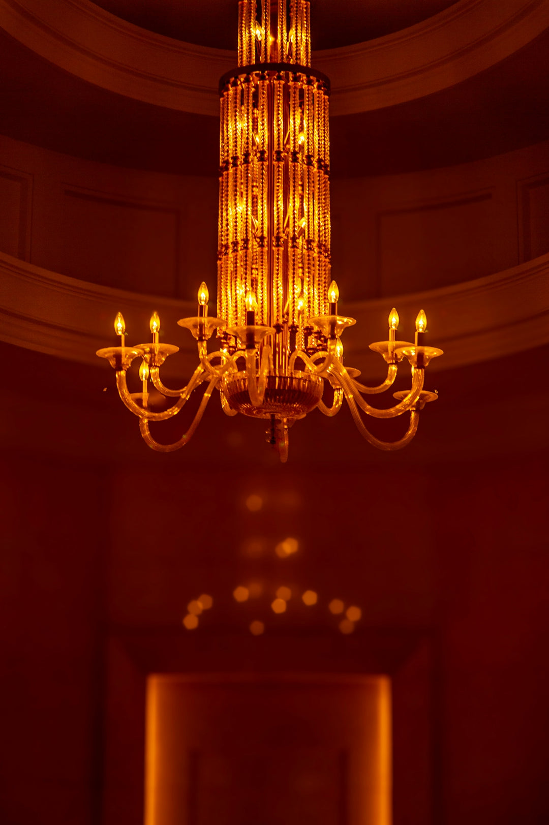 An ornate golden chandelier illuminated in a dimly lit room.