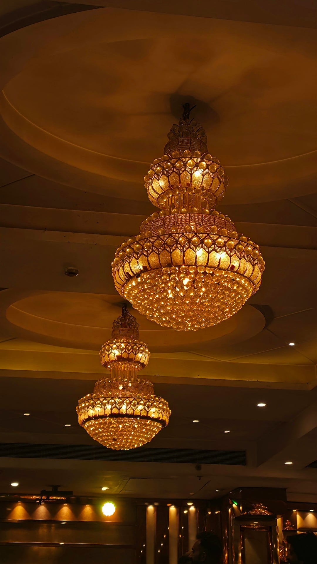 Two ornate crystal chandeliers hanging from ceiling