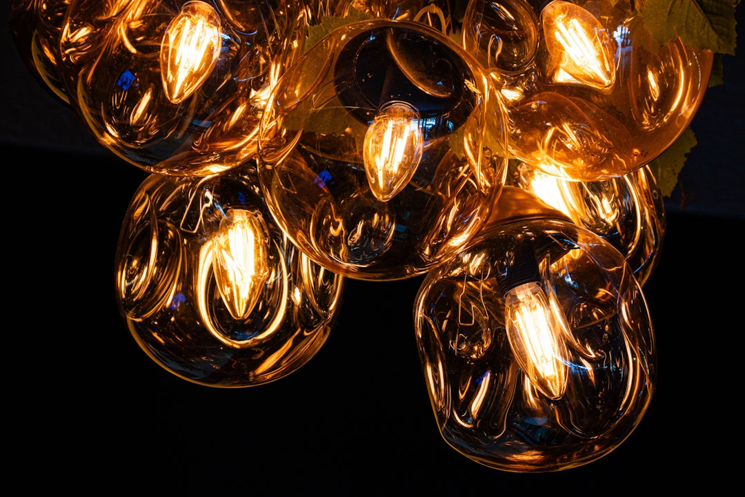 Multiple glowing amber light bulbs against a dark background.
